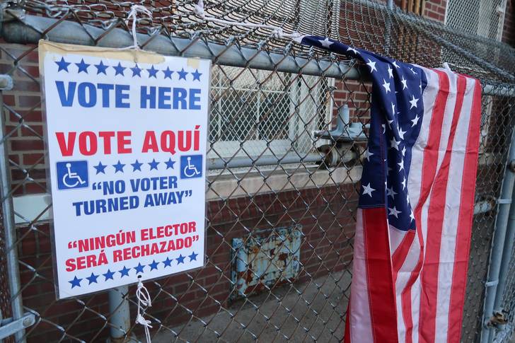 A voting information banner is seen on a metal chain fence at a polling station in Paterson, New Jersey, in 2020. New Jersey voters returned to the polls Tuesday to cast ballots in 12 Congressional races.